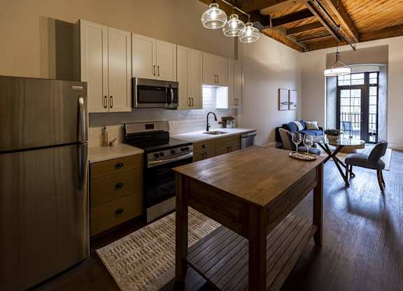 A kitchen with a wooden table and a refrigerator at The Dean at Creekview Apartments, Delaware