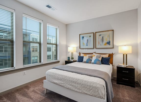 a bedroom with a large bed and three windows at Preston Ridge, Cary, 27513