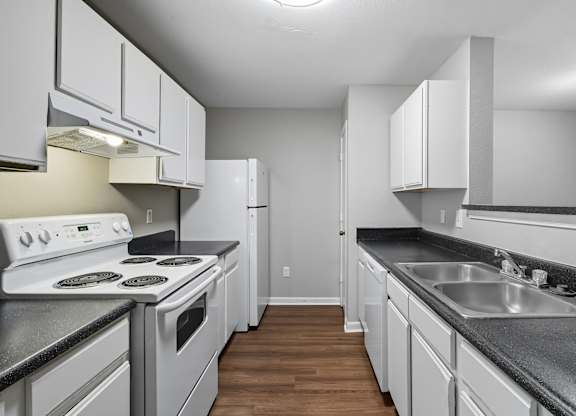 A kitchen with white appliances and cabinets. at Greens at Stonecreek, Georgia