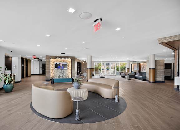 A modern office lobby with a reception desk and seating area.