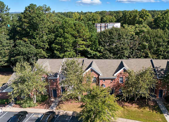 A large building surrounded by trees and a parking lot. at Greens at Stonecreek, Lithonia