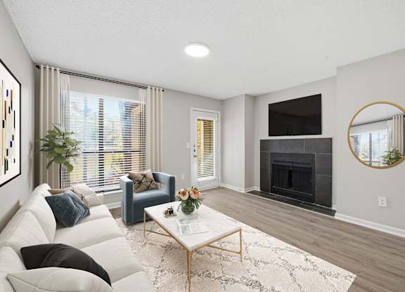 A living room with a white couch, a coffee table, and a fireplace at Brampton Moors, Cary, NC, 27513