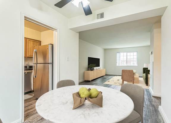 A kitchen with a refrigerator and a dining table with chairs at The Fields of Silver Spring, Silver Spring