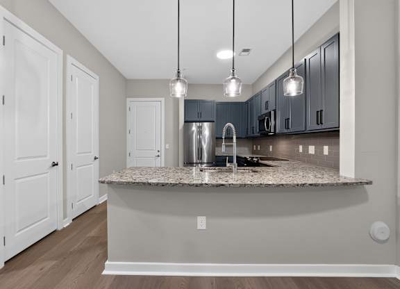 A kitchen with a granite countertop and a sink.
