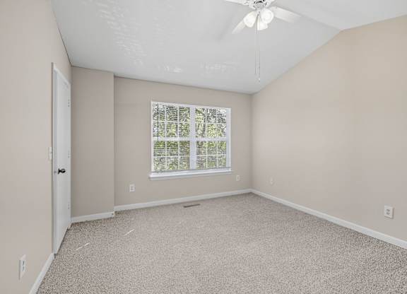 Empty room with a window and a ceiling fan. at Greens at Stonecreek, Lithonia, GA