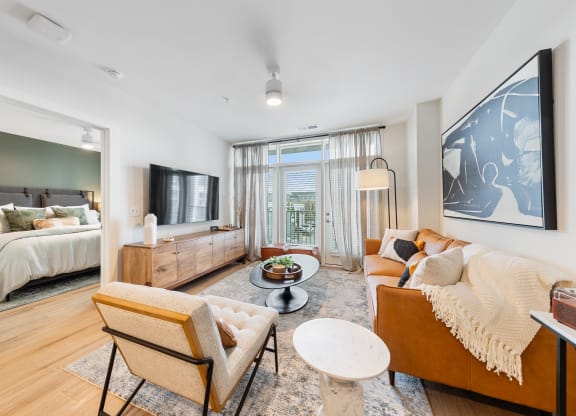a living room with a couch and a chair and a bedroom with a bed at Hawkins Press, Charlotte, 28203