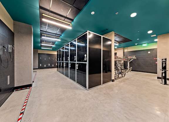 A gym with a row of mirrors on the wall at Hawkins Press Apartments, North Carolina, 28203