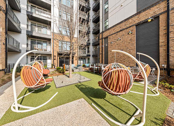 A playground with two orange and white swings at Hawkins Press Apartments, Charlotte, NC, 28203