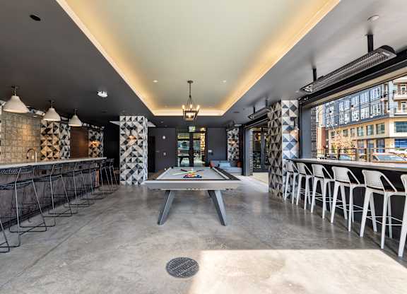 A modern dining area with a long table and chairs at Hawkins Press Apartments, Charlotte, NC, 28203