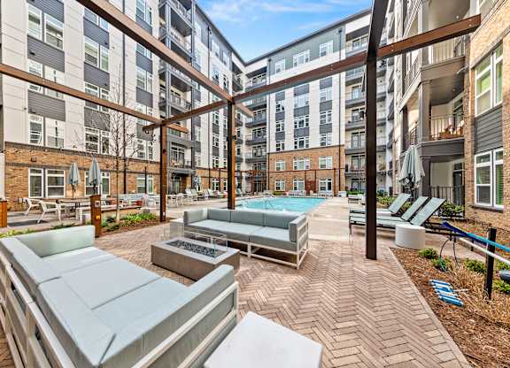 A patio area with a pool and seating area at Hawkins Press Apartments, Charlotte, NC, 28203