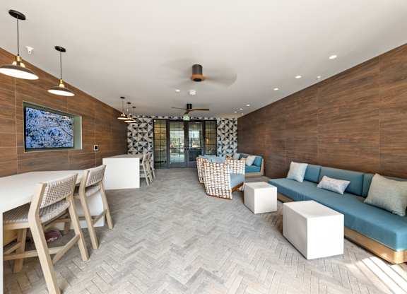 A modern living room with a wooden wall and a grey carpet at Hawkins Press Apartments, Charlotte, North Carolina