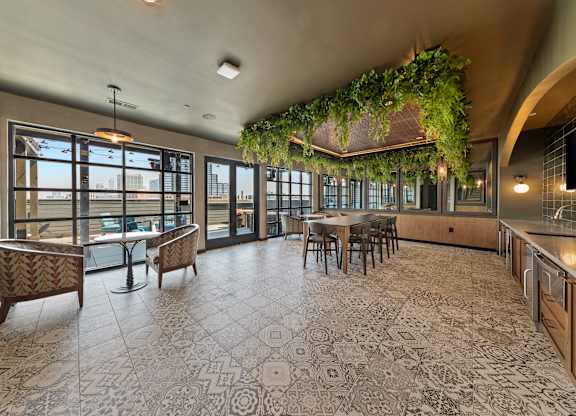 A large open space with a patterned floor and a table surrounded by chairs at Hawkins Press Apartments, Charlotte, 28203