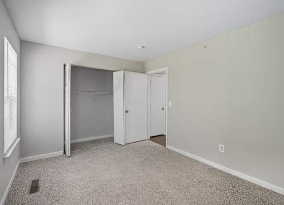 A room with a carpeted floor and a white closet with a sliding door. at Greens at Stonecreek, Georgia, 30038