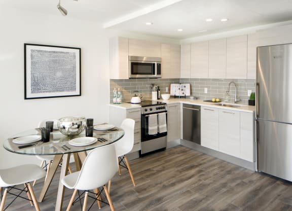 a kitchen with stainless steel appliances and a table with chairs at 1305 Dock Street, Baltimore