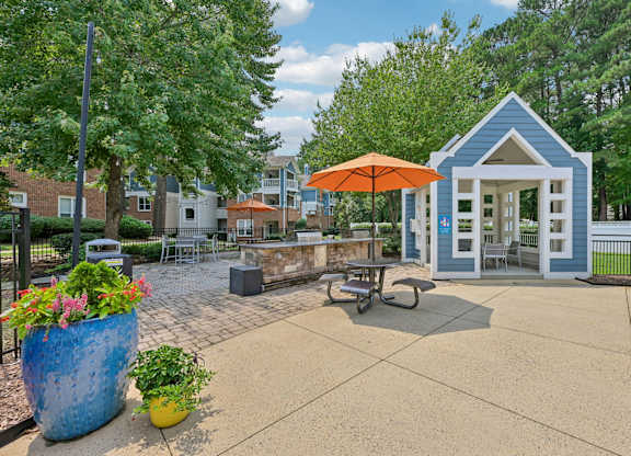 A blue and white building with an orange umbrella sits in the middle of a courtyard.