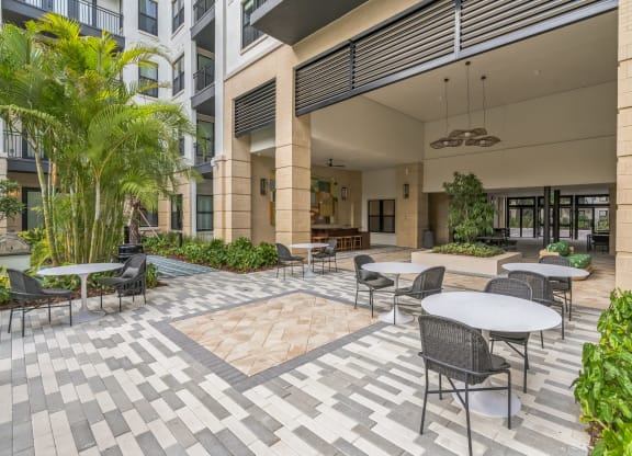 a courtyard with tables and chairs and a building in the background  at La Unión, Tampa, 33605