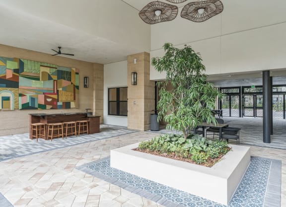 a lobby with a garden and a painting on the wall  at La Unión, Tampa, FL