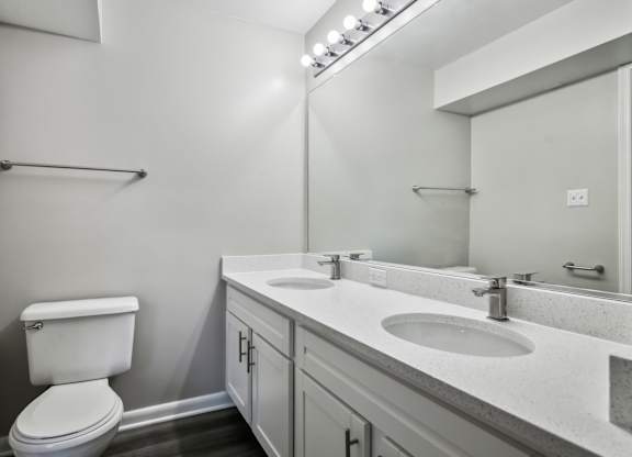 A white toilet sits next to a sink in a bathroom at Shenandoah Station Apartments, Triangle, 22172