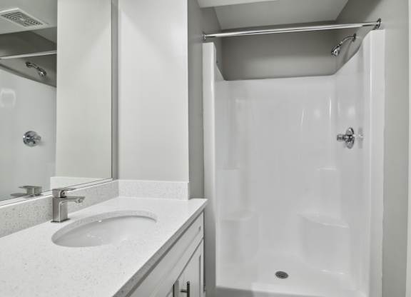 A white bathroom with a sink and a shower at Shenandoah Station Apartments, Triangle, Virginia
