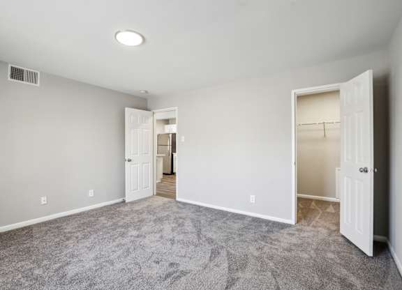 A room with carpeted floor and two open doors at Shenandoah Station Apartments, Triangle, 22172