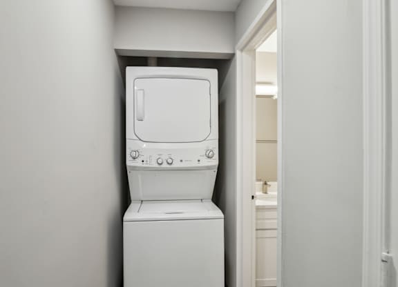 A white washing machine in a small room at Shenandoah Station Apartments, Triangle, VA