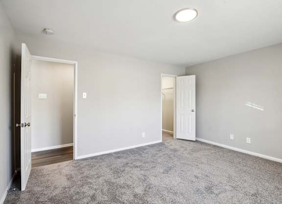 A room with a carpeted floor and two open doors at Shenandoah Station Apartments, Virginia 22172