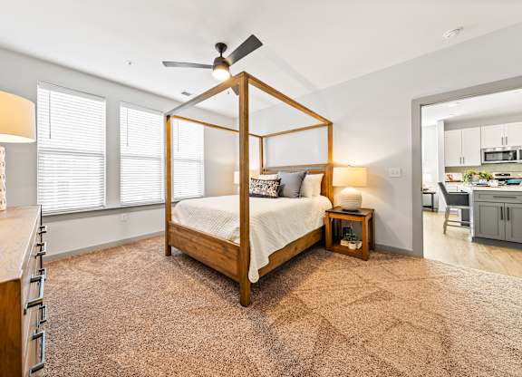 A bedroom with a four poster bed and a ceiling fan.
