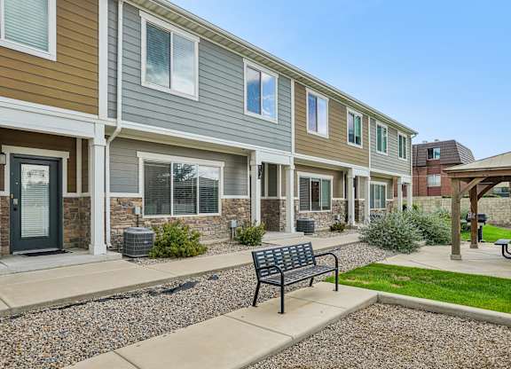 A row of houses with a bench in front of them.