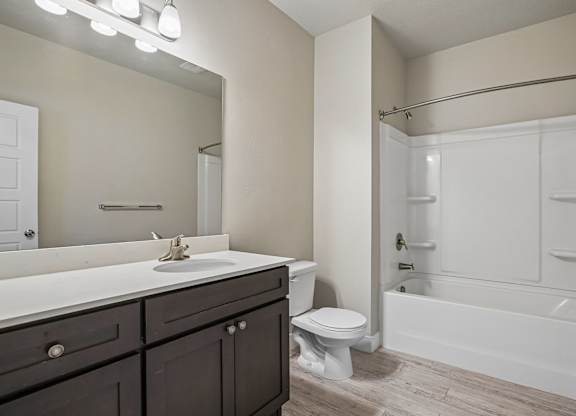 A bathroom with a white sink, toilet, and bathtub.