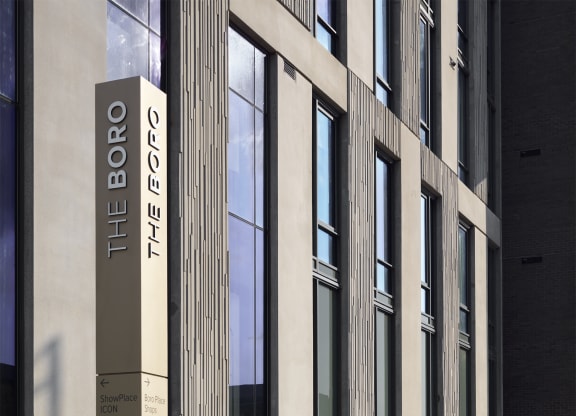 a person sitting on a bench in front of a building at The Boro, Tysons, 22102