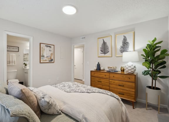 a bedroom with a bed and a dresser and a bathroom at St. Andrews Reserve, Wilmington, NC