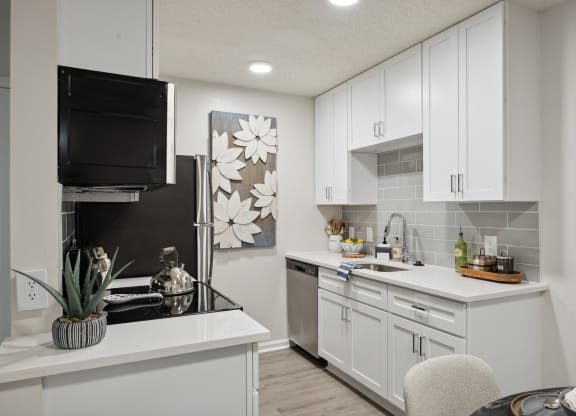 an open kitchen with white cabinets and a sink and a refrigerator at St. Andrews Reserve, Wilmington, NC
