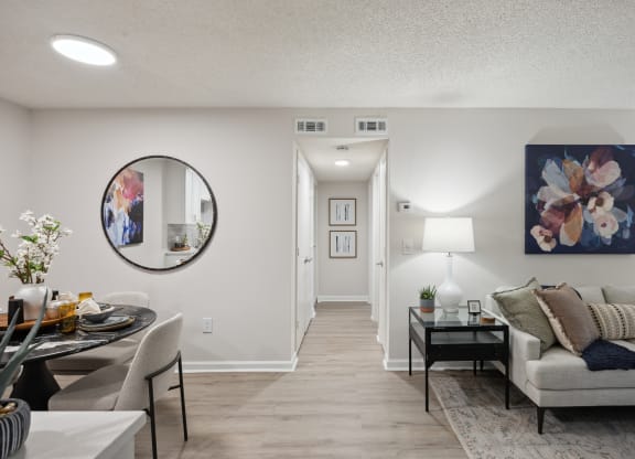 the living room and dining room of an apartment with a couch and a table at St. Andrews Reserve, Wilmington, NC