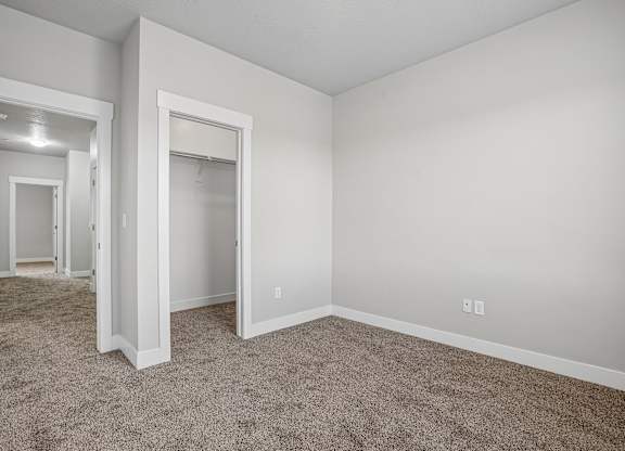 A large, empty room with carpeted flooring and white walls.