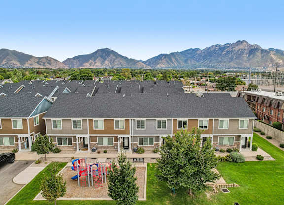 A large apartment complex with a playground in the front yard.