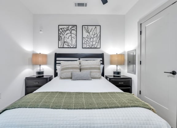 a bedroom with a large bed and two lamps