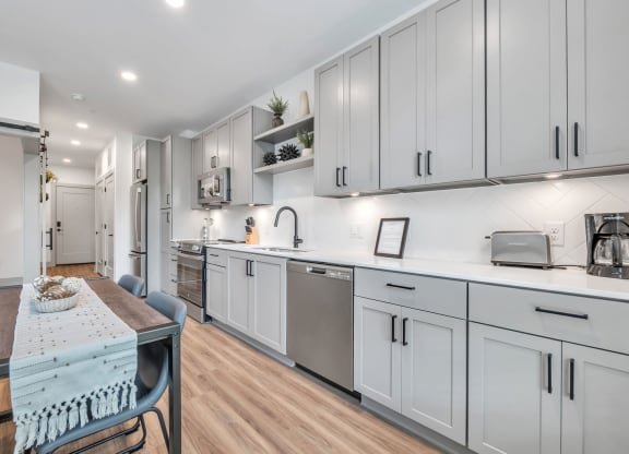 a kitchen with white cabinets and a dining table