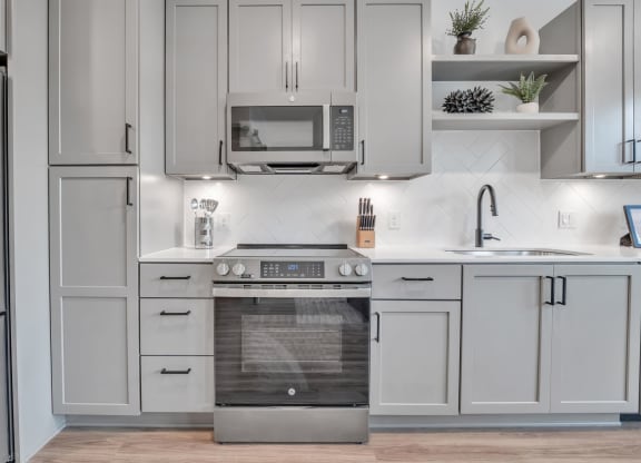 a white kitchen with stainless steel appliances and white cabinets