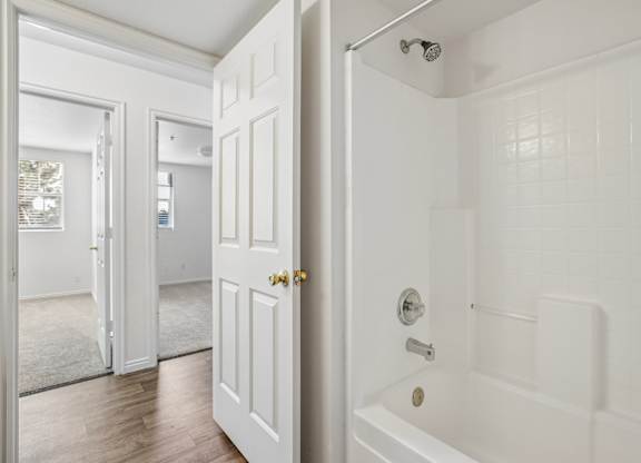A white bathroom with a tub and shower.