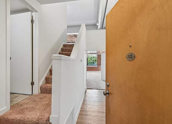 A brown door with a number 112 on it.