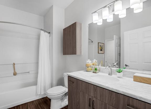 A white bathroom with a toilet, sink, and shower.