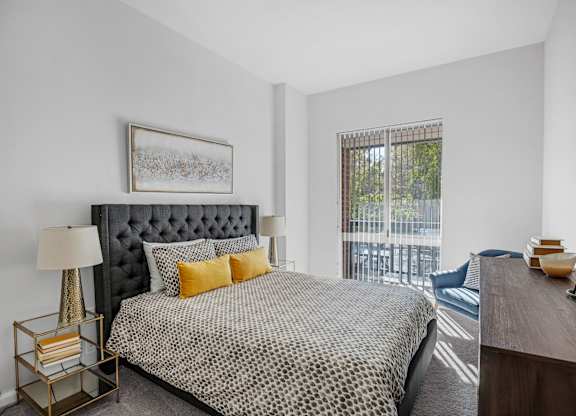 A bedroom with a large bed and a balcony.