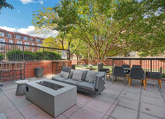 A patio with a fire pit and seating area.