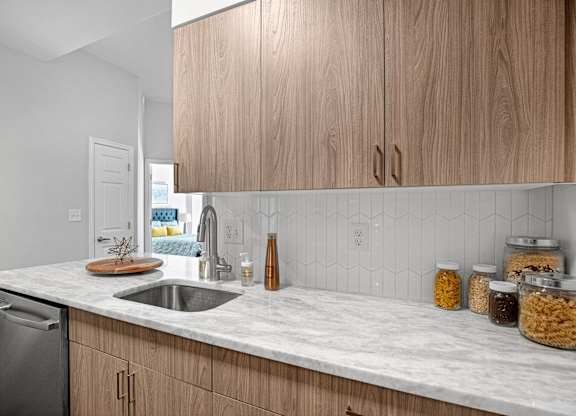 A kitchen with wooden cabinets and a marble countertop.