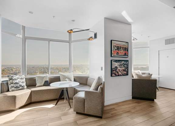 A living room with a large window overlooking a cityscape.