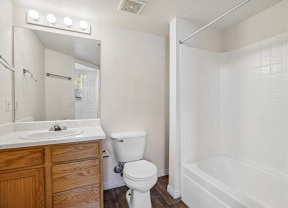 A white bathroom with a toilet, sink, and bathtub.