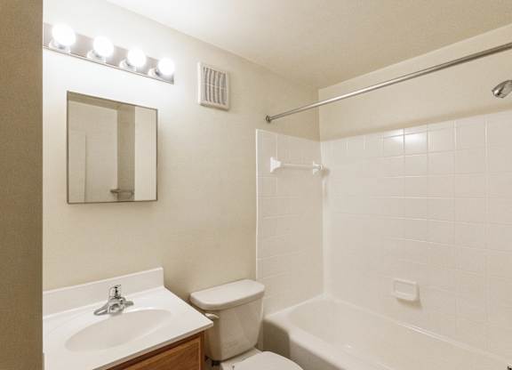 A white bathroom with a sink, toilet, and bathtub.