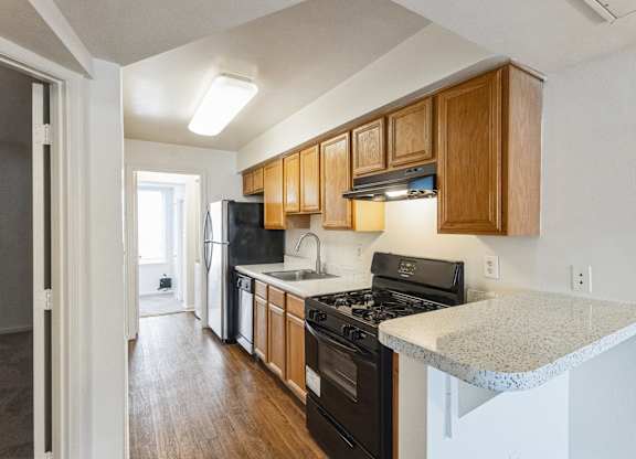 A kitchen with wooden cabinets and black appliances.