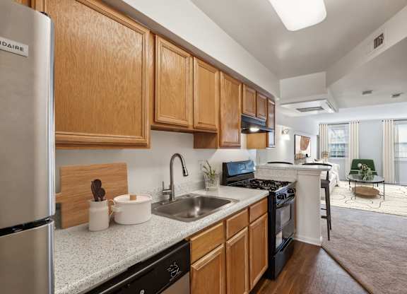 A kitchen with wooden cabinets and a stainless steel refrigerator at The Fields of Bethesda, Chevy Chase, MD