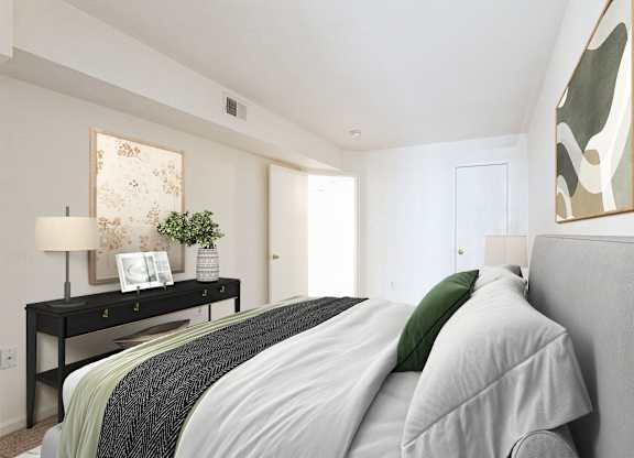 A bedroom with a bed, nightstand, and a painting on the wall at The Fields of Bethesda, Chevy Chase, MD